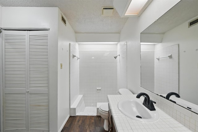 821 Dublin Dr Unit 203, Richardson, TX 75080 - full bathroom featuring a tile shower, toilet, a textured ceiling, and a closet