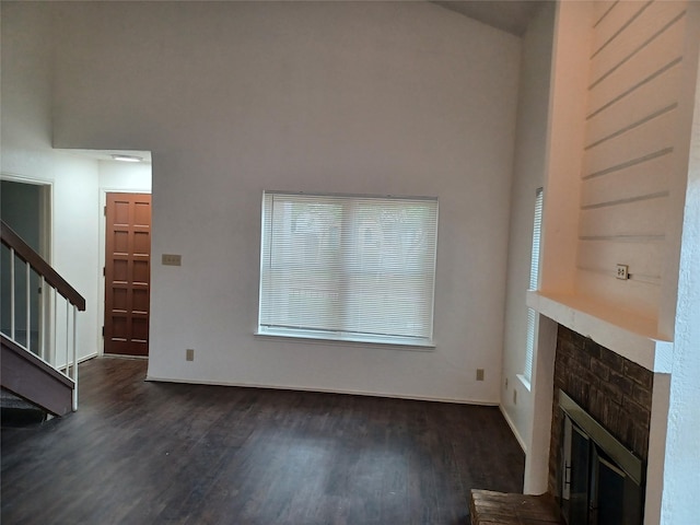 unfurnished living room with dark wood-type flooring and a fireplace