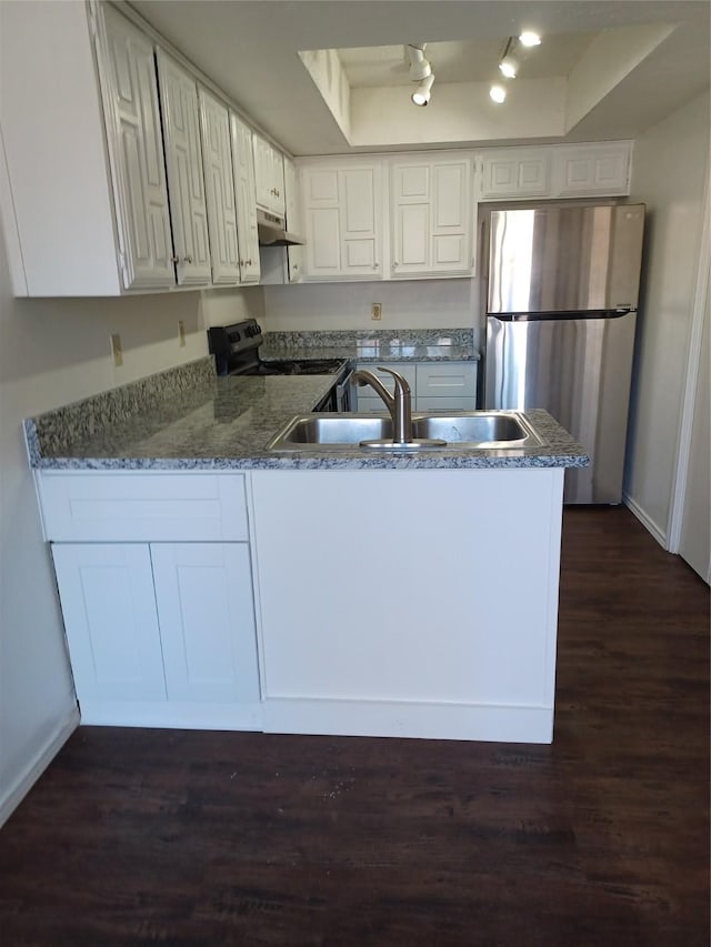 kitchen with sink, stainless steel refrigerator, a tray ceiling, white cabinetry, and black range with electric cooktop