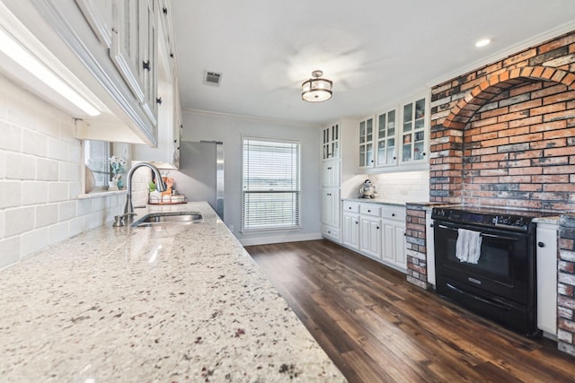 kitchen with light stone countertops, white cabinetry, decorative backsplash, sink, and black electric range