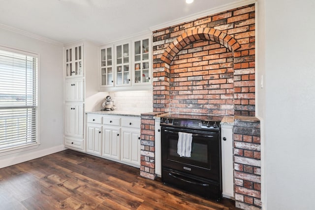 kitchen with light stone countertops, white cabinets, dark wood-type flooring, black electric range oven, and crown molding