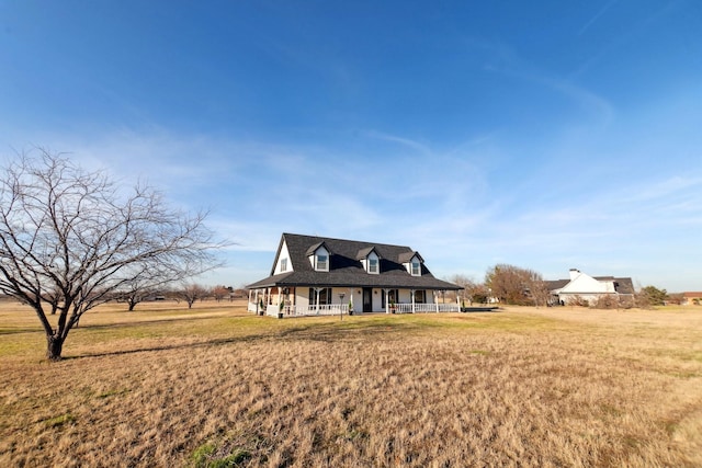 view of front of house featuring a front lawn and a rural view