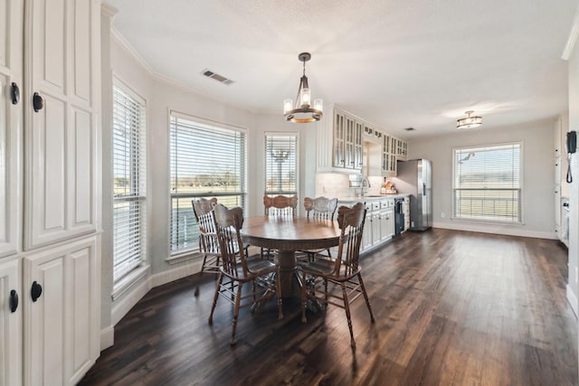 dining room with dark wood-type flooring, a wealth of natural light, and sink