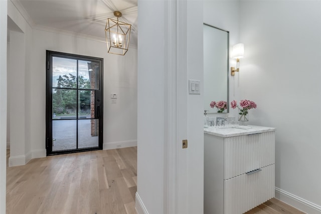 interior space with wood-type flooring, vanity, crown molding, and a chandelier