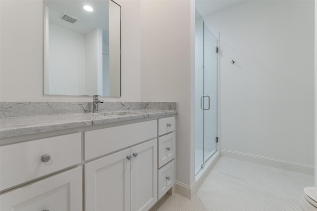 bathroom featuring toilet, walk in shower, vanity, and tile patterned flooring