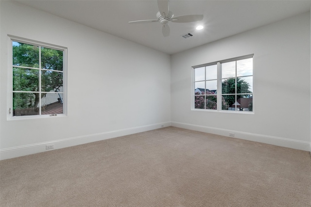 unfurnished room with light carpet, ceiling fan, and plenty of natural light