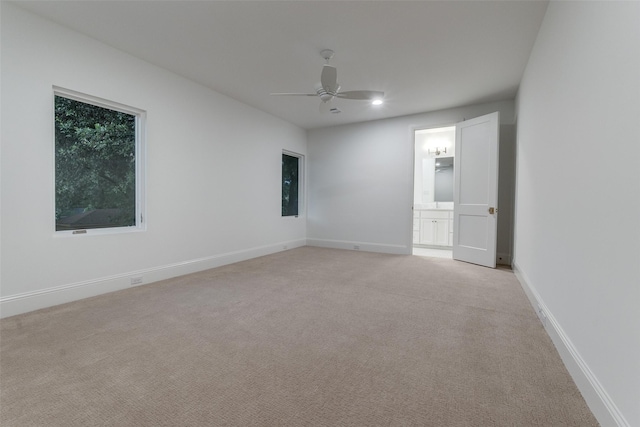 empty room with ceiling fan and light colored carpet