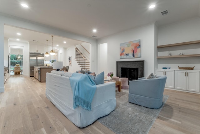 living room with crown molding and light hardwood / wood-style flooring