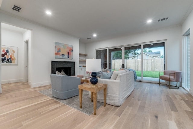 living room featuring light hardwood / wood-style floors and ornamental molding