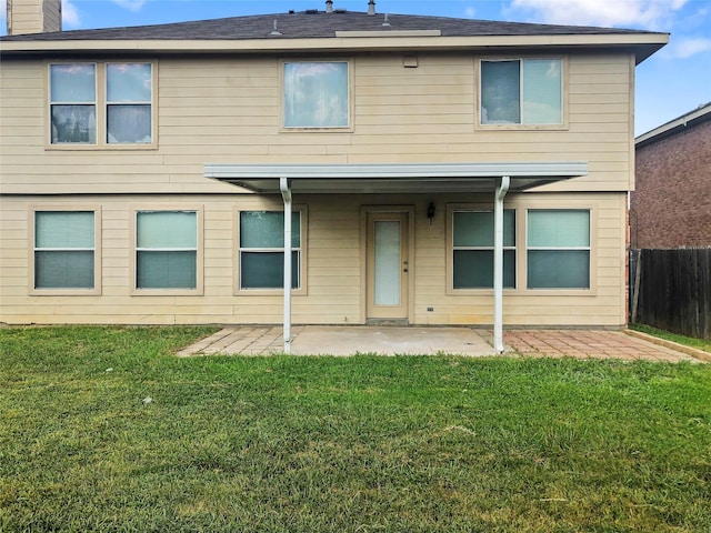 back of house featuring a lawn and a patio area