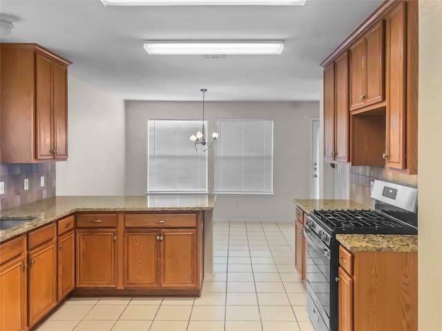 kitchen featuring kitchen peninsula, stainless steel gas range oven, tasteful backsplash, a notable chandelier, and hanging light fixtures