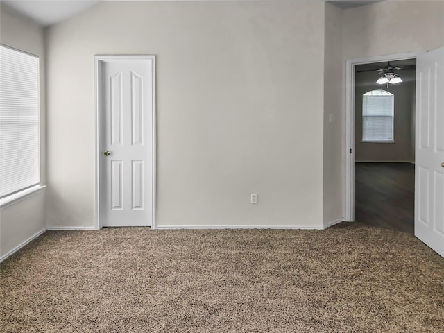 carpeted spare room featuring vaulted ceiling and a healthy amount of sunlight