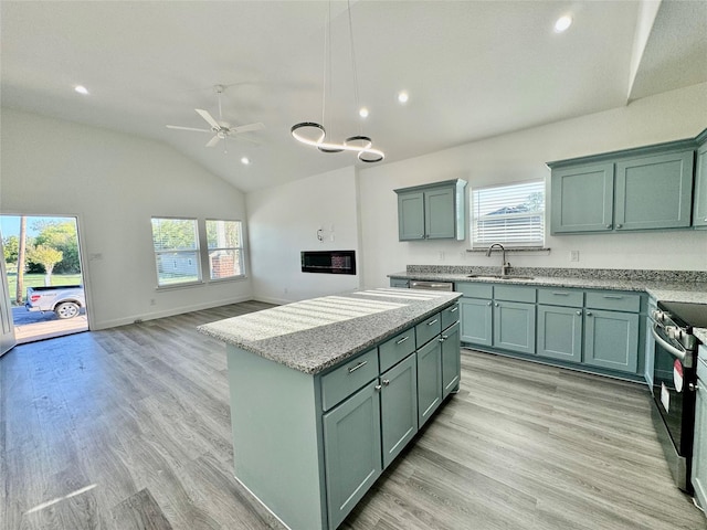 kitchen with pendant lighting, sink, stainless steel electric range oven, ceiling fan, and light stone counters