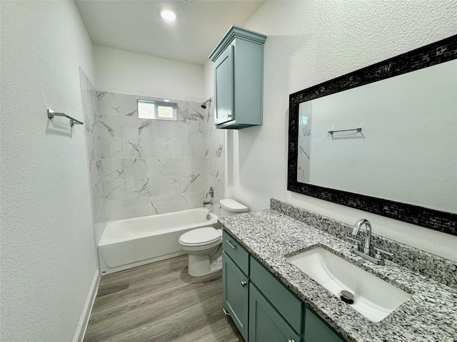 full bathroom with toilet, tiled shower / bath, hardwood / wood-style flooring, and vanity