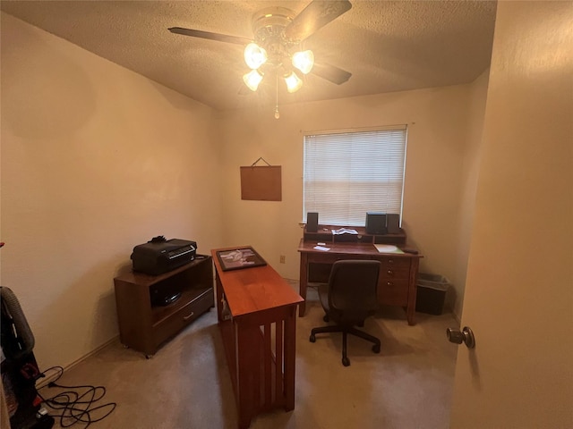 carpeted office space featuring ceiling fan and a textured ceiling