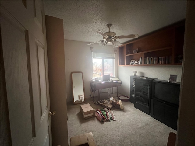 misc room with ceiling fan, a textured ceiling, and carpet