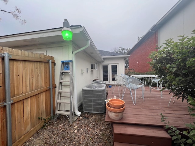 deck featuring a wall mounted air conditioner, french doors, and central air condition unit