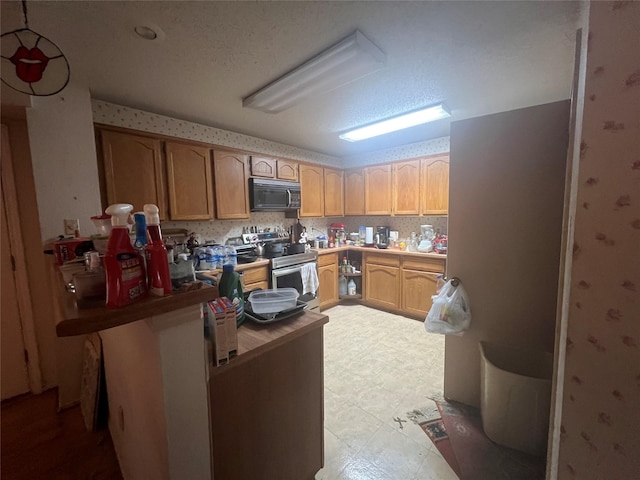 kitchen with stainless steel electric stove, a textured ceiling, light brown cabinets, and kitchen peninsula