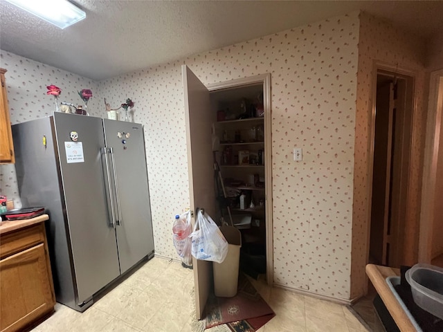 kitchen with a textured ceiling and high quality fridge