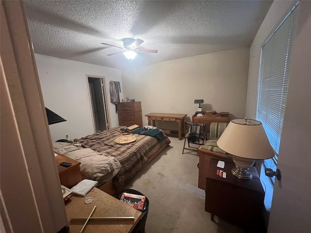 bedroom featuring ceiling fan, a textured ceiling, and light carpet