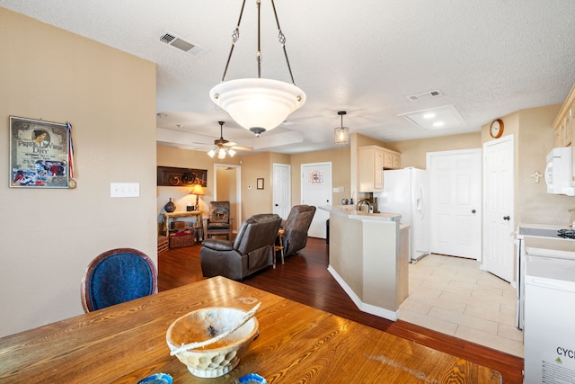 dining room featuring ceiling fan, a textured ceiling, and light wood-type flooring