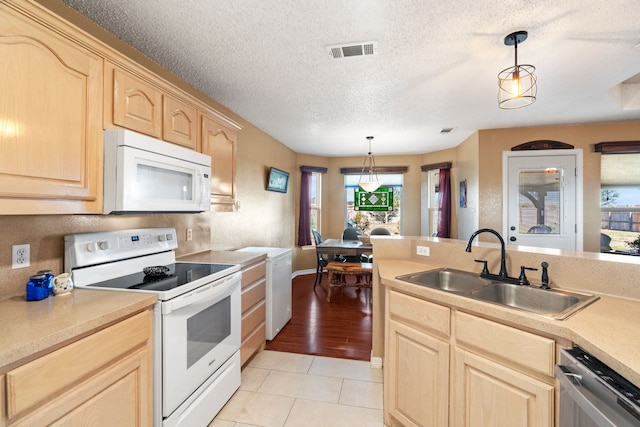 kitchen with sink, light brown cabinetry, hanging light fixtures, and white appliances