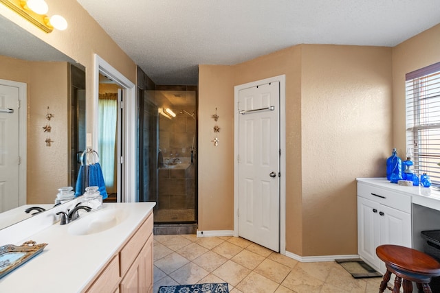 bathroom featuring a textured ceiling, an enclosed shower, vanity, and tile patterned flooring