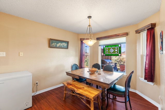 dining room with dark hardwood / wood-style floors and a textured ceiling