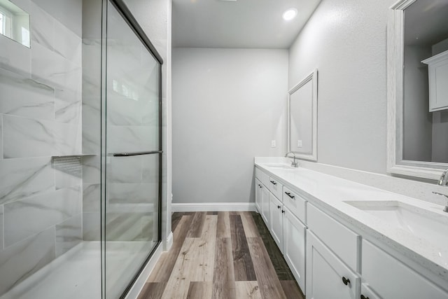 bathroom with hardwood / wood-style flooring, a shower with door, and vanity