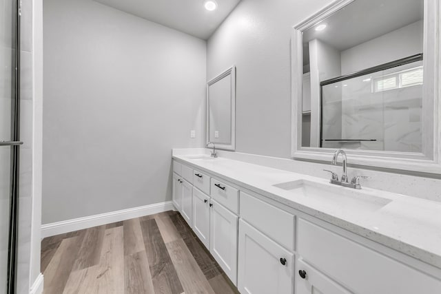 bathroom featuring hardwood / wood-style flooring, a shower with door, and vanity