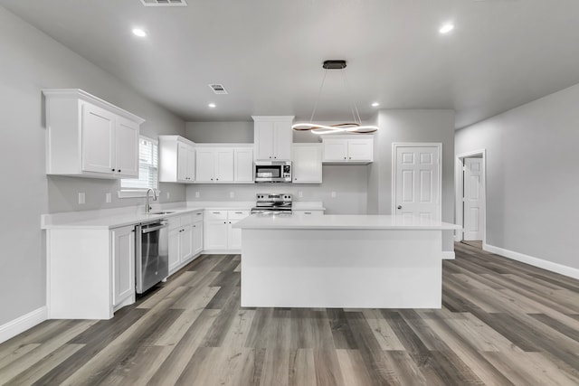 kitchen with stainless steel appliances, white cabinets, and a center island