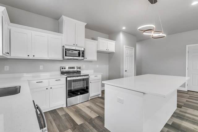 kitchen with white cabinets, appliances with stainless steel finishes, and a center island