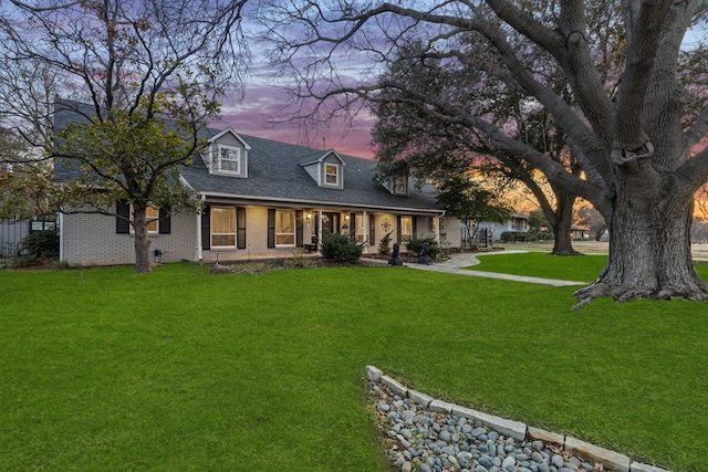 cape cod home with a porch and a lawn