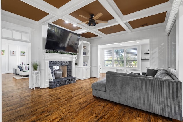 living room with hardwood / wood-style floors, coffered ceiling, a stone fireplace, ornamental molding, and beam ceiling