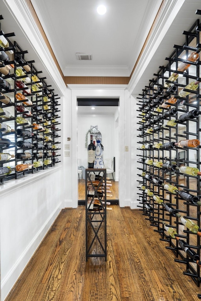 wine cellar with hardwood / wood-style flooring and crown molding