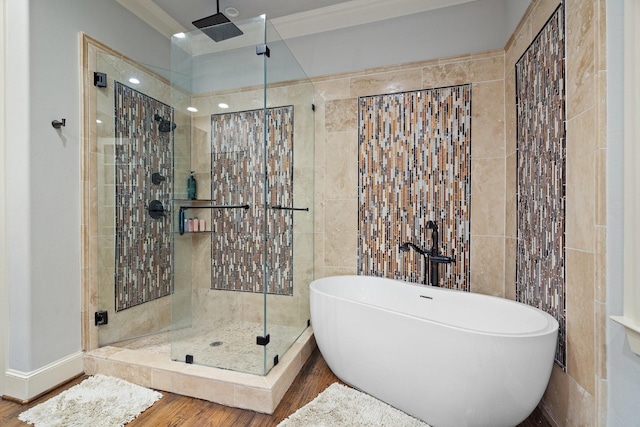 bathroom with hardwood / wood-style floors, crown molding, tile walls, and shower with separate bathtub