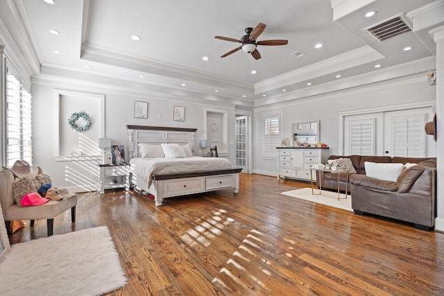 110 Quiet Hill Cir, Copper Canyon, TX 76226 - bedroom featuring a raised ceiling, wood finished floors, multiple windows, ornamental molding, and baseboards