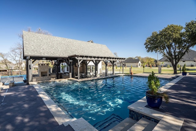 view of pool featuring a patio area, an outdoor stone fireplace, and a gazebo