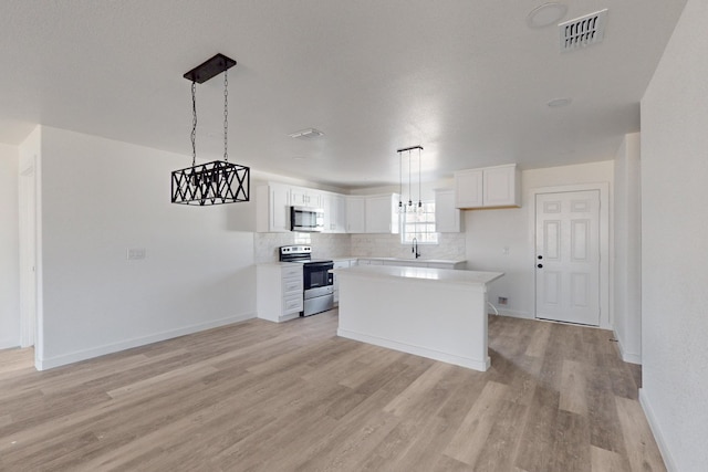 kitchen with pendant lighting, white cabinetry, a center island, and stainless steel appliances