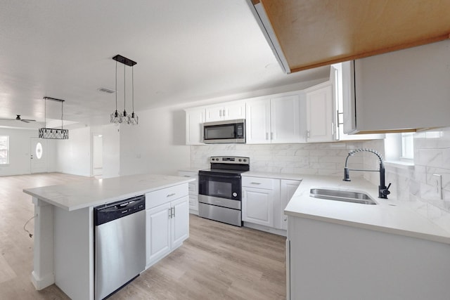 kitchen with white cabinets, appliances with stainless steel finishes, a center island, and sink