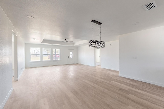 interior space featuring ceiling fan, light hardwood / wood-style flooring, and a raised ceiling