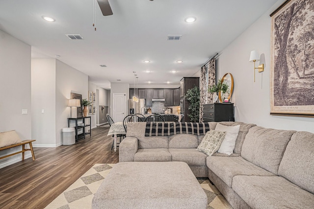 living room featuring ceiling fan and dark hardwood / wood-style floors