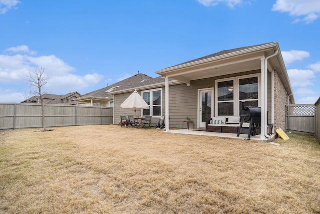 rear view of property featuring a patio area and a lawn