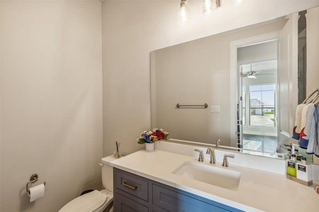 bathroom featuring toilet, vanity, and ceiling fan