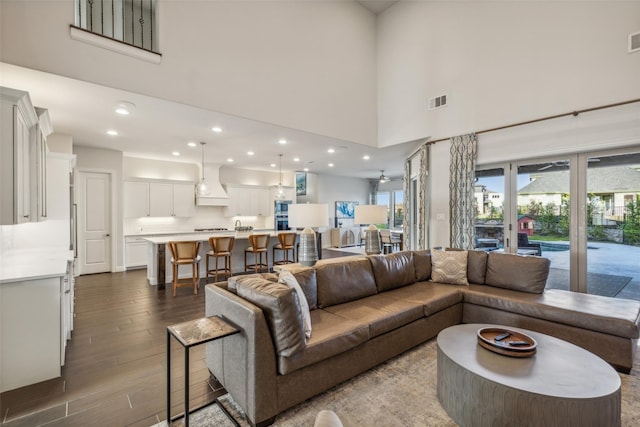 living room with hardwood / wood-style floors and a towering ceiling