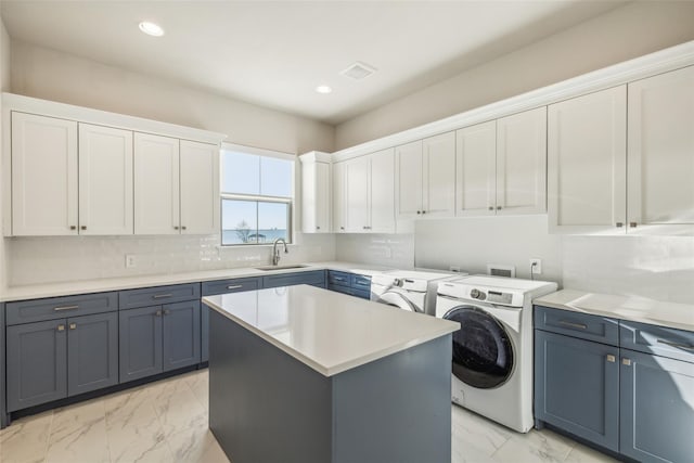 laundry room with cabinets, washer and clothes dryer, and sink