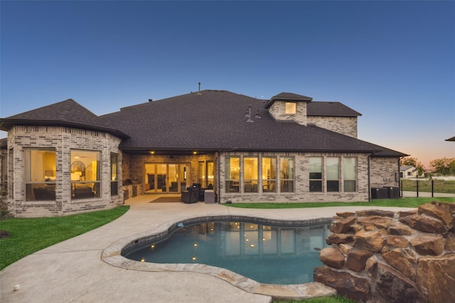 pool at dusk featuring a patio area