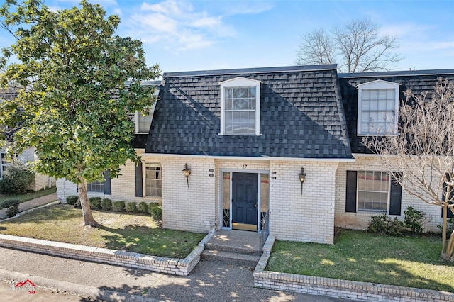 cape cod home with a front lawn