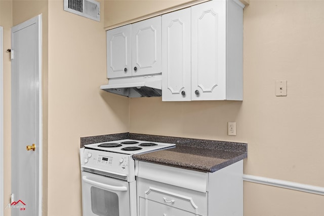 kitchen with electric stove and white cabinets