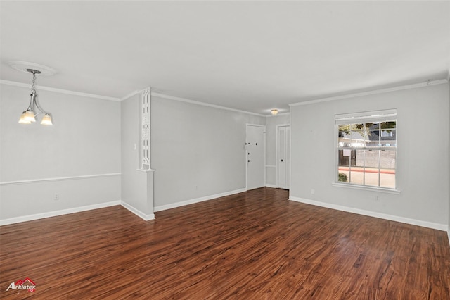 spare room with dark wood-type flooring, a chandelier, and crown molding